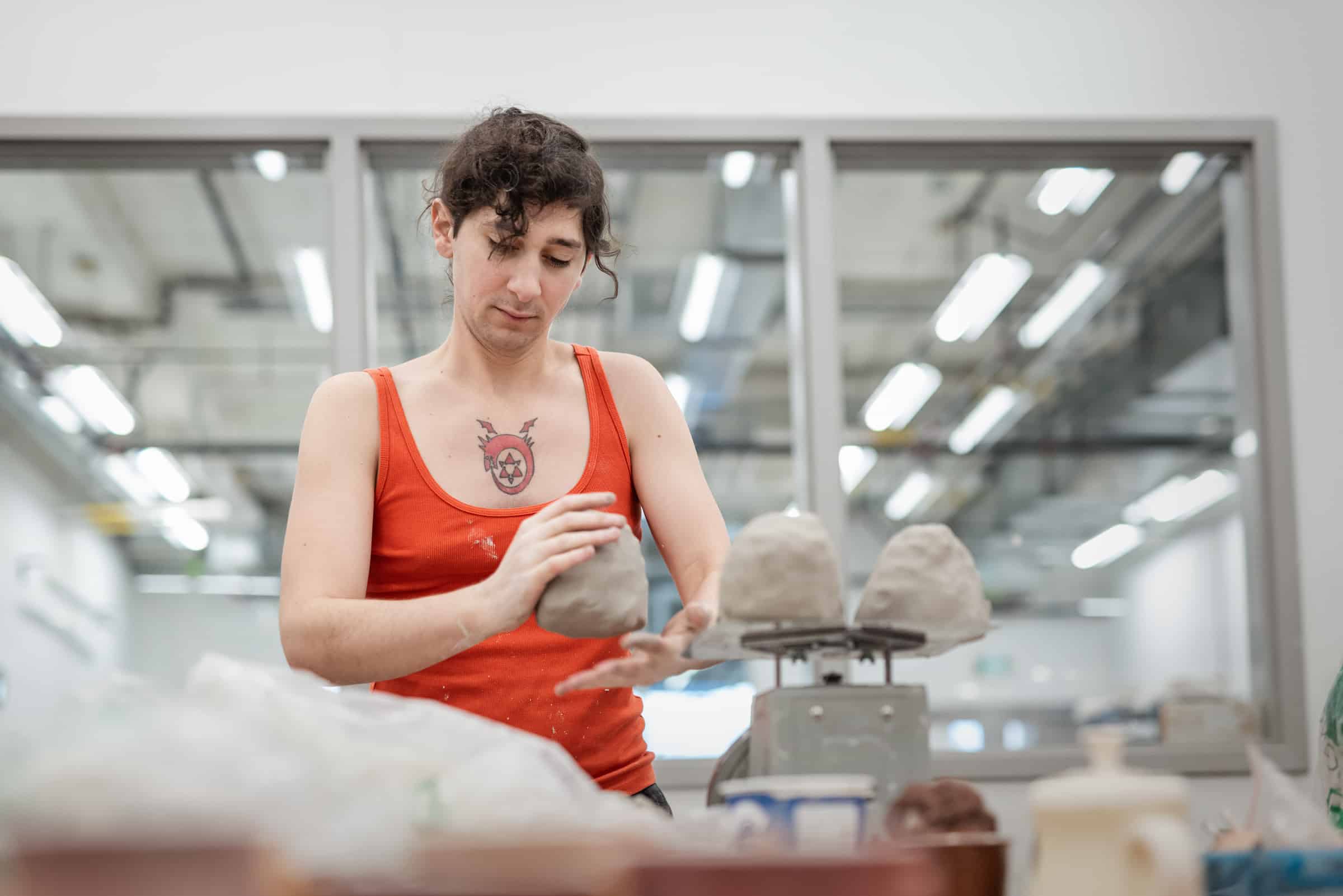 Student weighing clay in the ceramics studio.