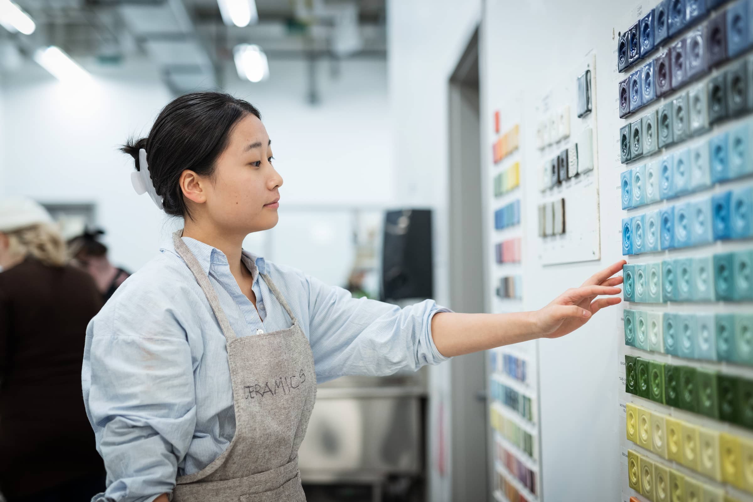 Student selecting glaze colours in the ceramics studio.