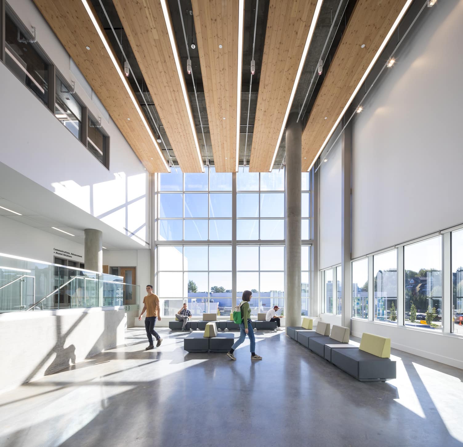 We are looking at the Zone 3 Gallery on Level 2. The far wall is entirely windows, so the gallery is bright and airy and full of sunlight. Modular seating is in the spaces, giving the people in the photo a place to sit and relax.