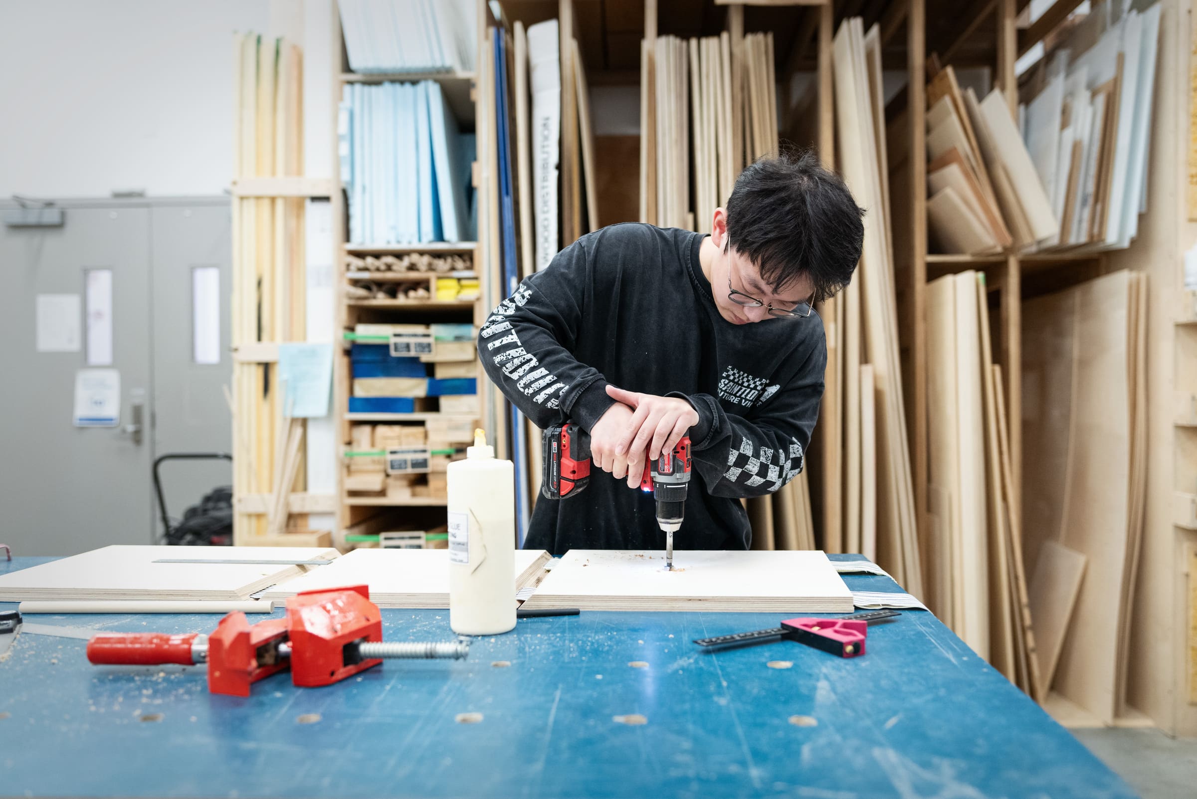 Student drilling wood in the Design Wood Shop.