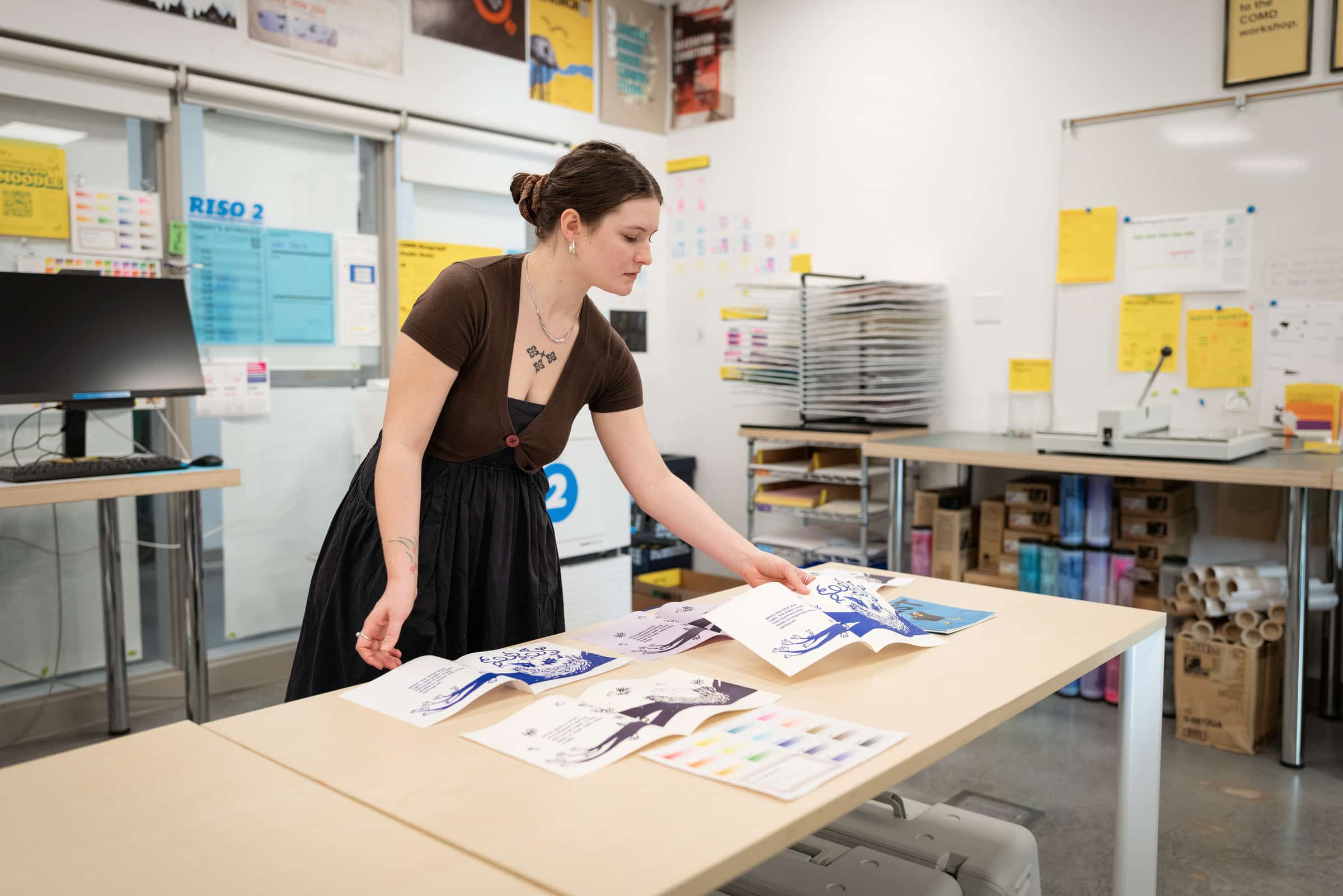 Communication Design student reviewing Risograph prints.