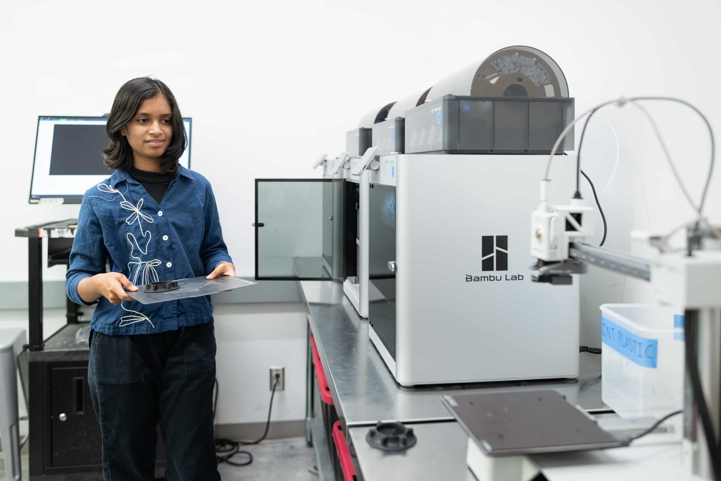 Student removing work from a 3D printer.