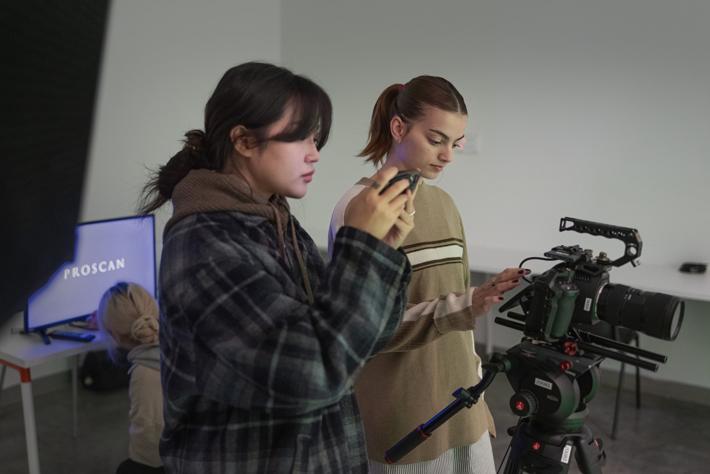 Students reviewing camera settings on a film shoot.