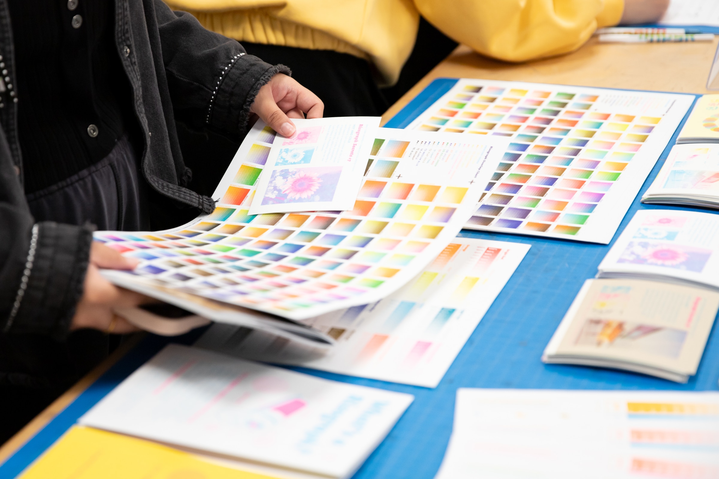 Student gathering colourful Risograph prints.
