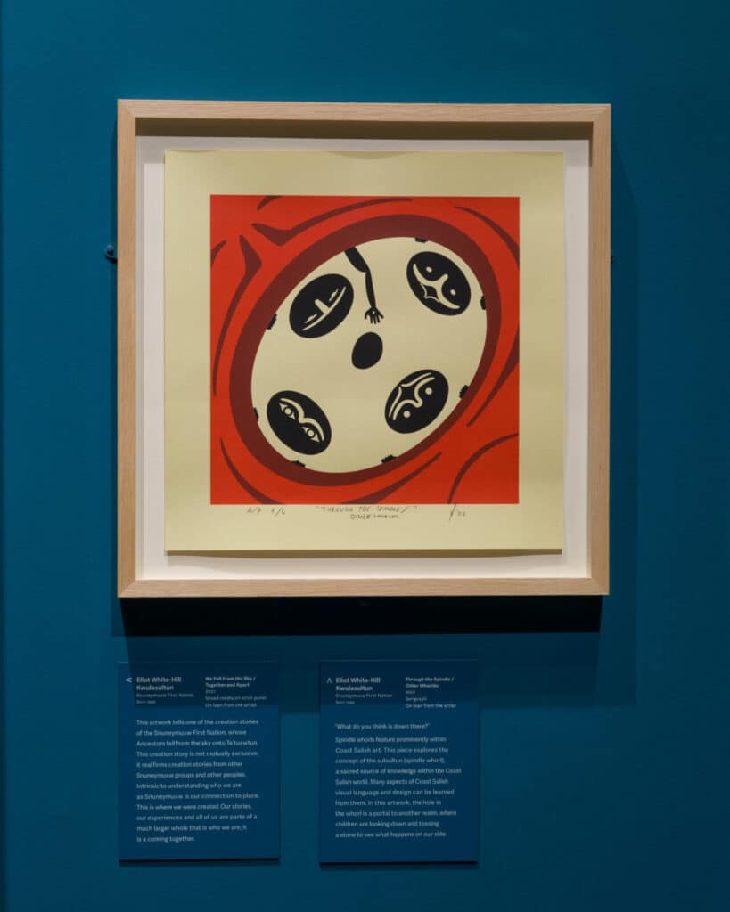 Framed print by Eliot White-Hill showing four stylized forms inside a circular red and cream design.