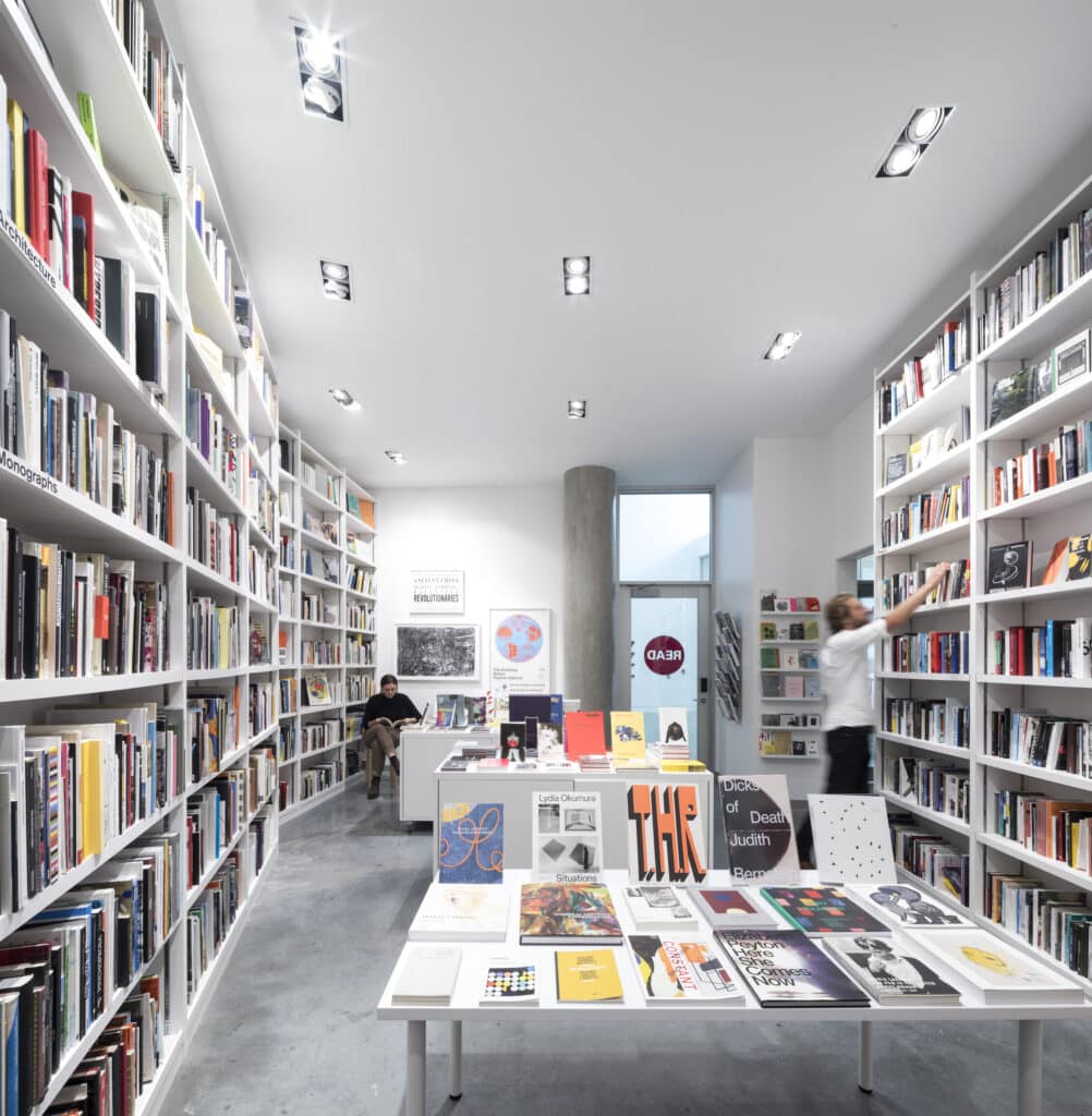 Interior of Read Books at ECU, showing tall shelves filled with books and a central display table with art and design publications.