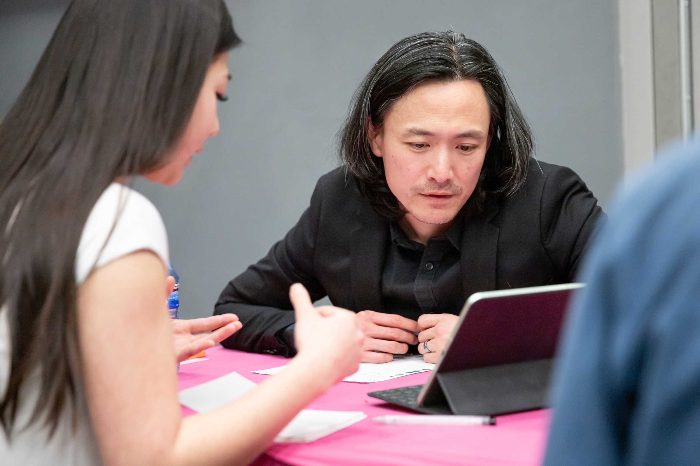 A professional mentor reviews a student’s work on a tablet during Creative Industry Day at Emily Carr University.