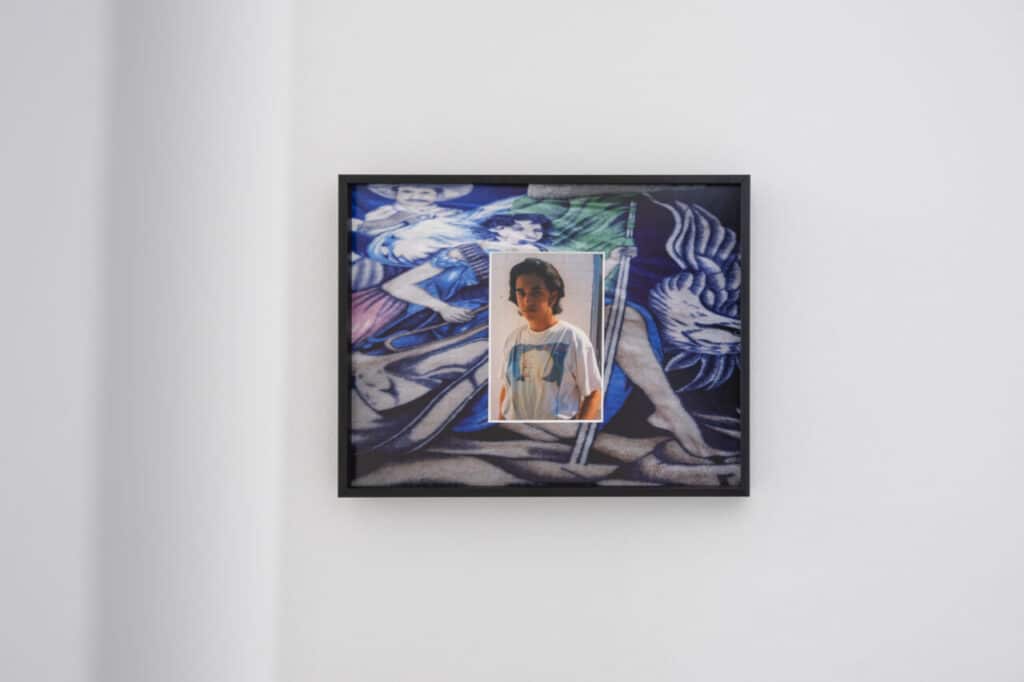 Framed artwork showing a photograph of a young person in a white T-shirt overlaid on a colourful background featuring painted figures and abstract shapes.