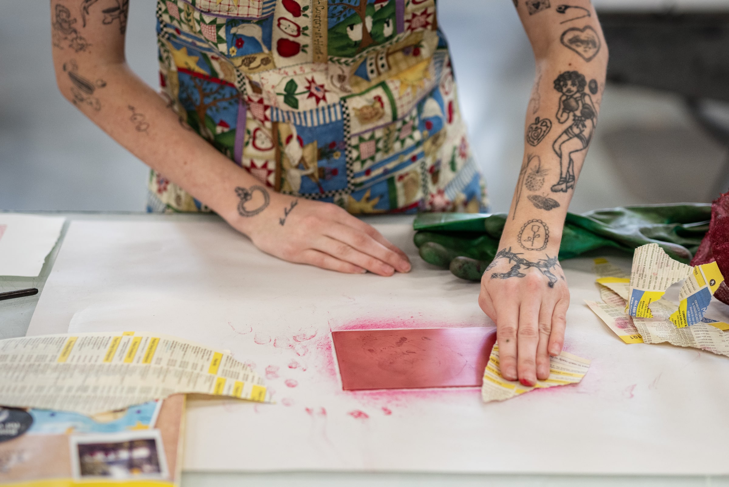Closeup of hands blotting ink off of a red print.