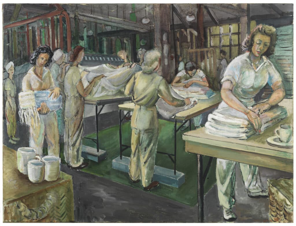 Women in uniform sort, fold, and press large piles of linens inside a busy industrial laundry.