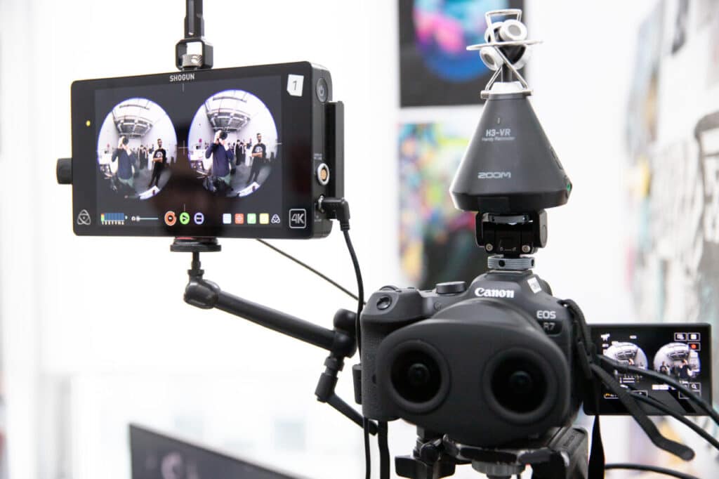 The output screen of a virtual-reality camera shows two circles reflecting a photographer and another person, neither of whom are otherwise visible.