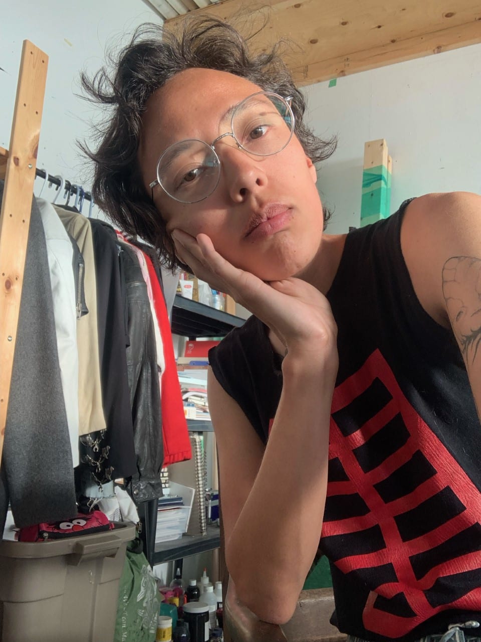 A photo of Whess Harman. He is wearing glasses and a black and red sleeveless tshirt.