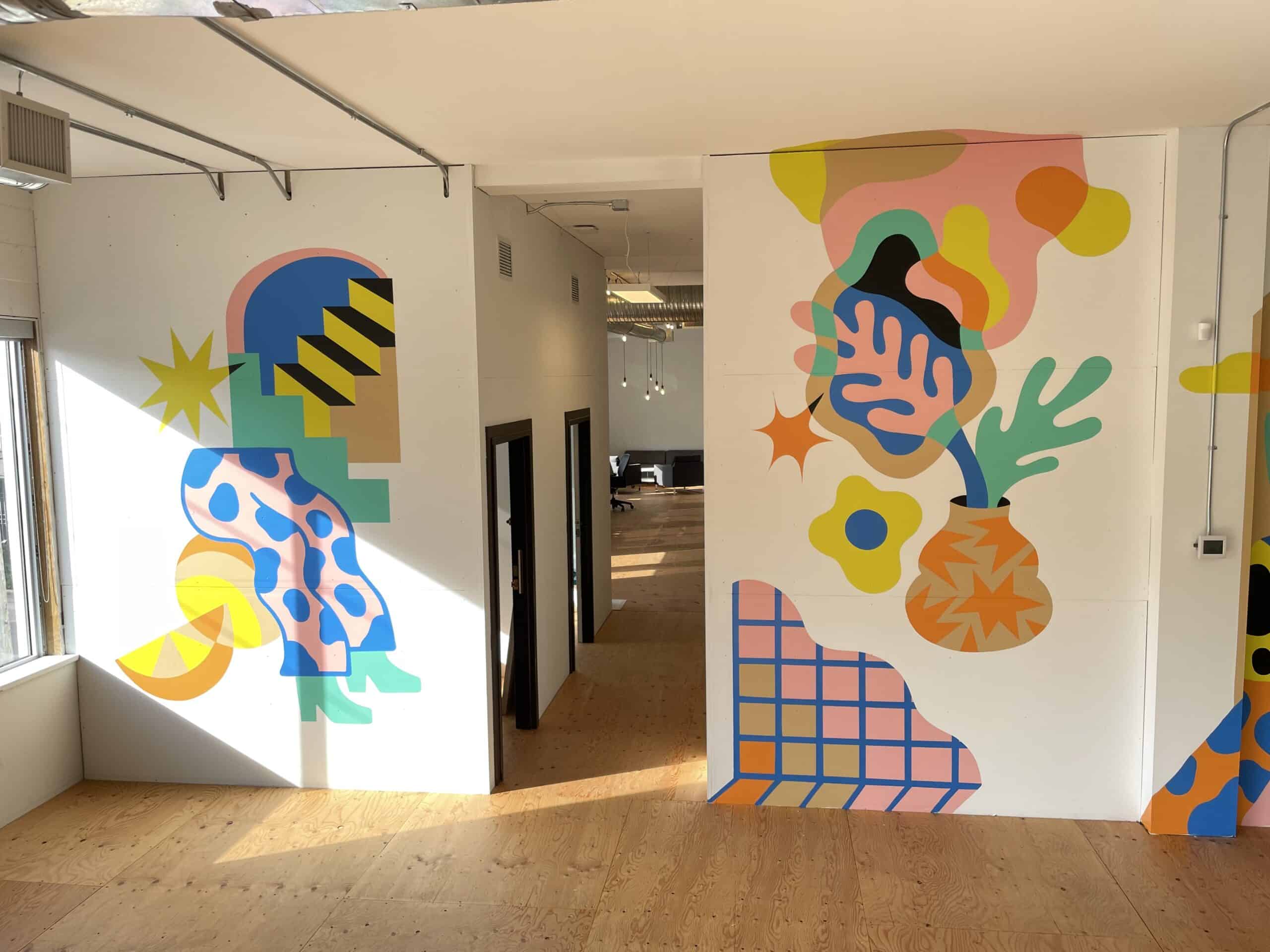 Interior hallway with large abstract wall murals in soft pink, green, blue and yellow.